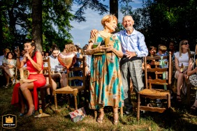 At La Maison du Saula, beaming grandparents share a moment of happiness together during the wedding ceremony, their smiles radiating affection and pride.
